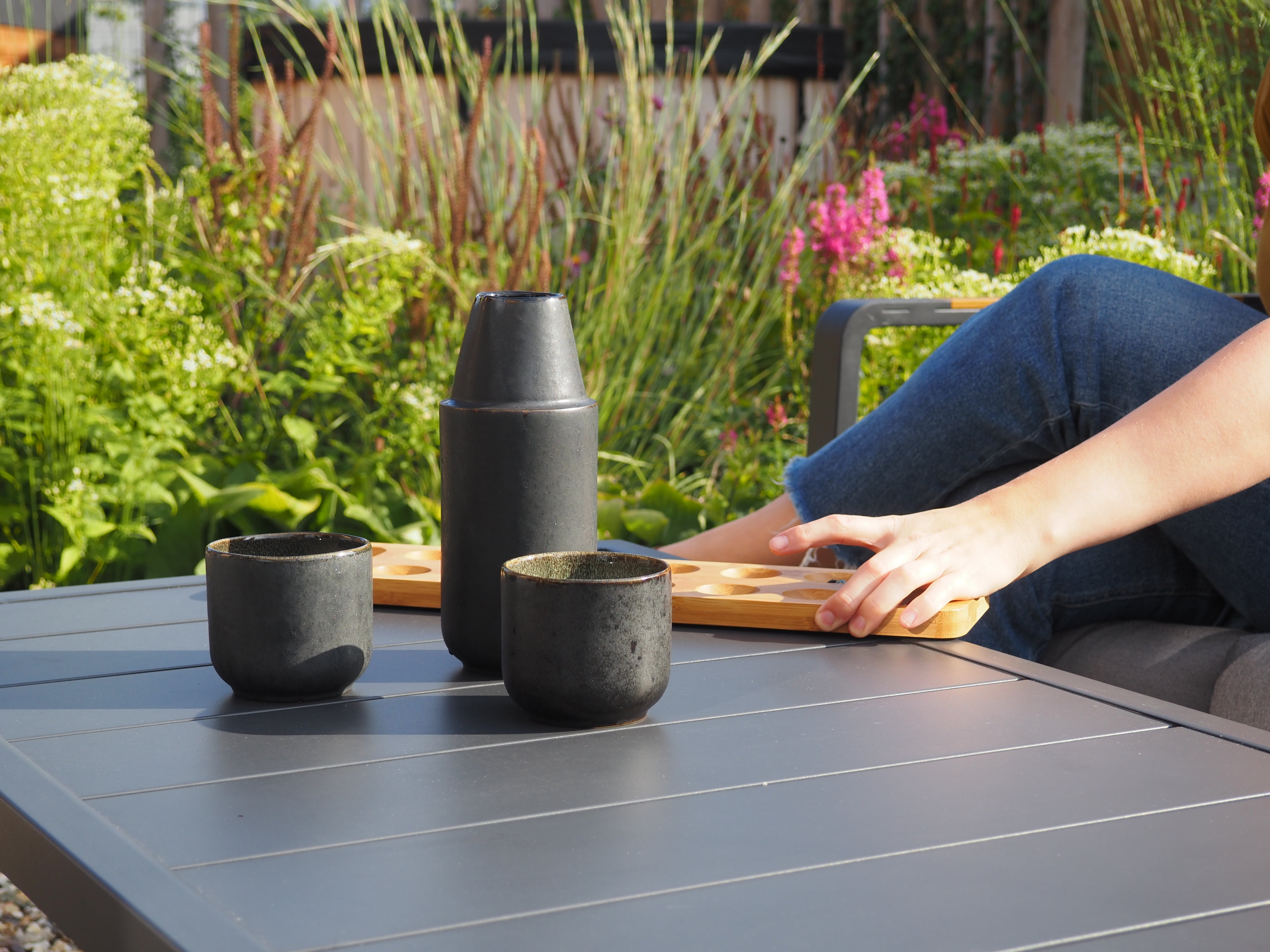 Keramik Karaffe mit zwei passendern Tassen aus Portugal auf Metalltisch draußen